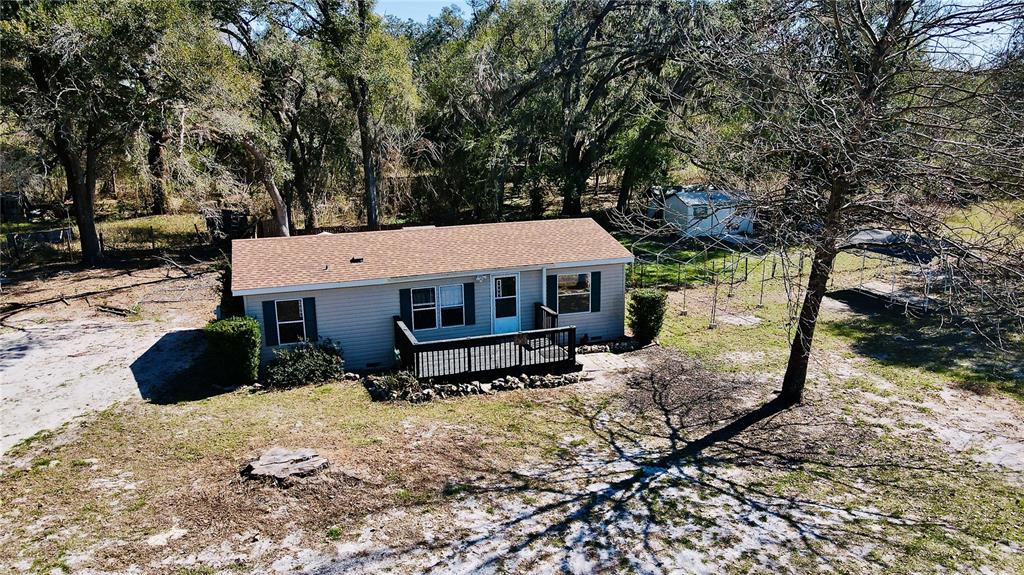 An aerial view of a single-story house with light siding and a wooden deck — 2665, 2639 E HWY 466, OXFORD, FL