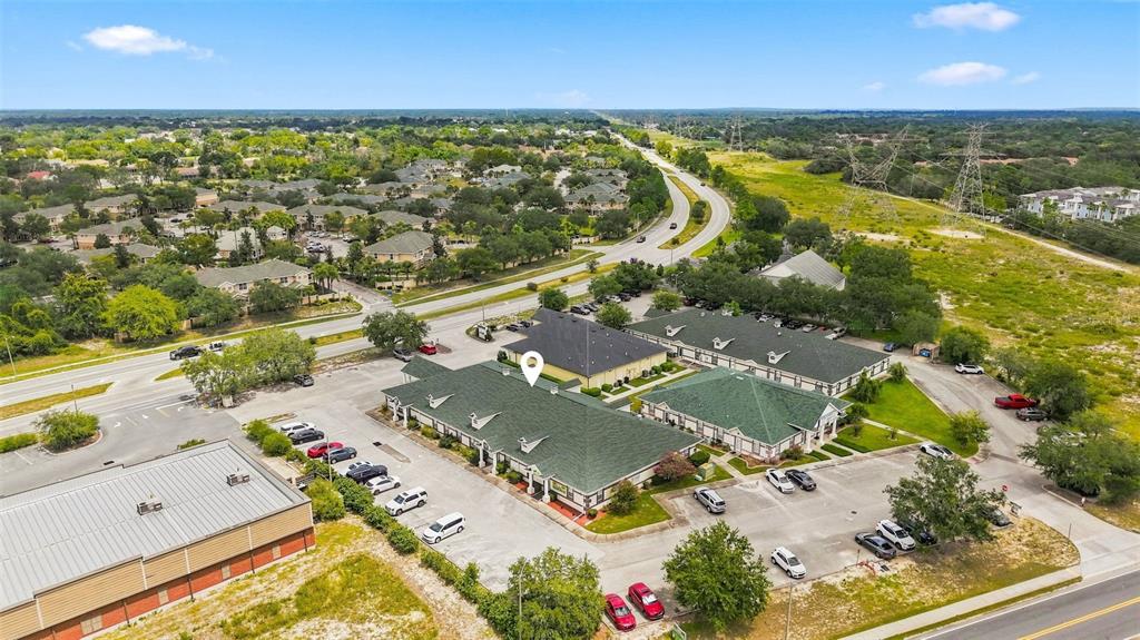 An aerial view shows a commercial office complex with green roofs and parking lots — 224 MARINER BOULEVARD, SPRING HILL, FL