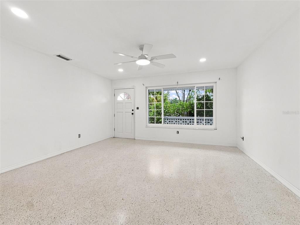 An empty room with white walls, a ceiling fan, and light-colored terrazzo flooring — 6100 35TH AVENUE N, ST PETERSBURG, FL