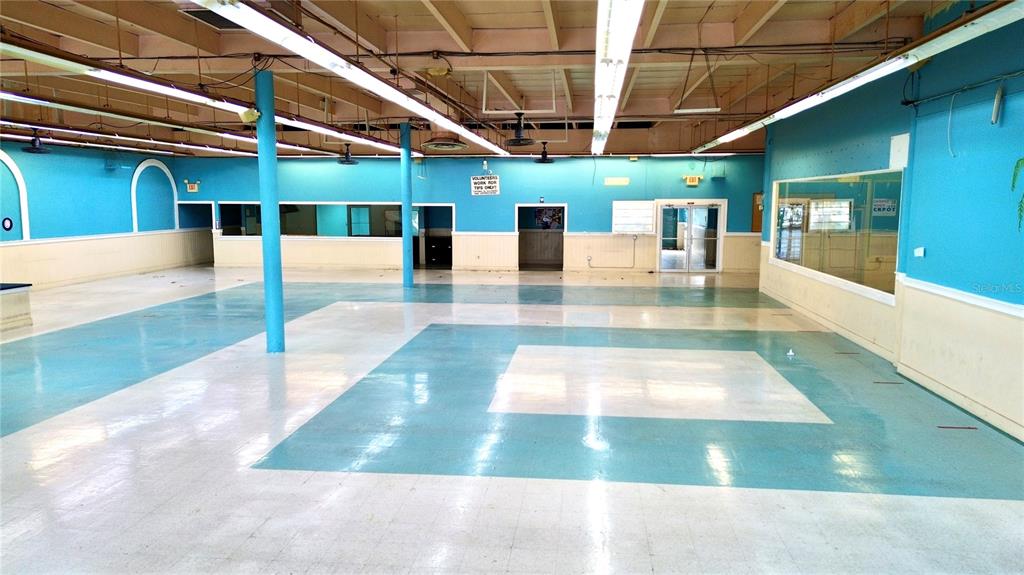 A large, open commercial space features turquoise walls, white wainscoting, and a patterned tile floor — 1091 W MAIN STREET, AVON PARK, FL