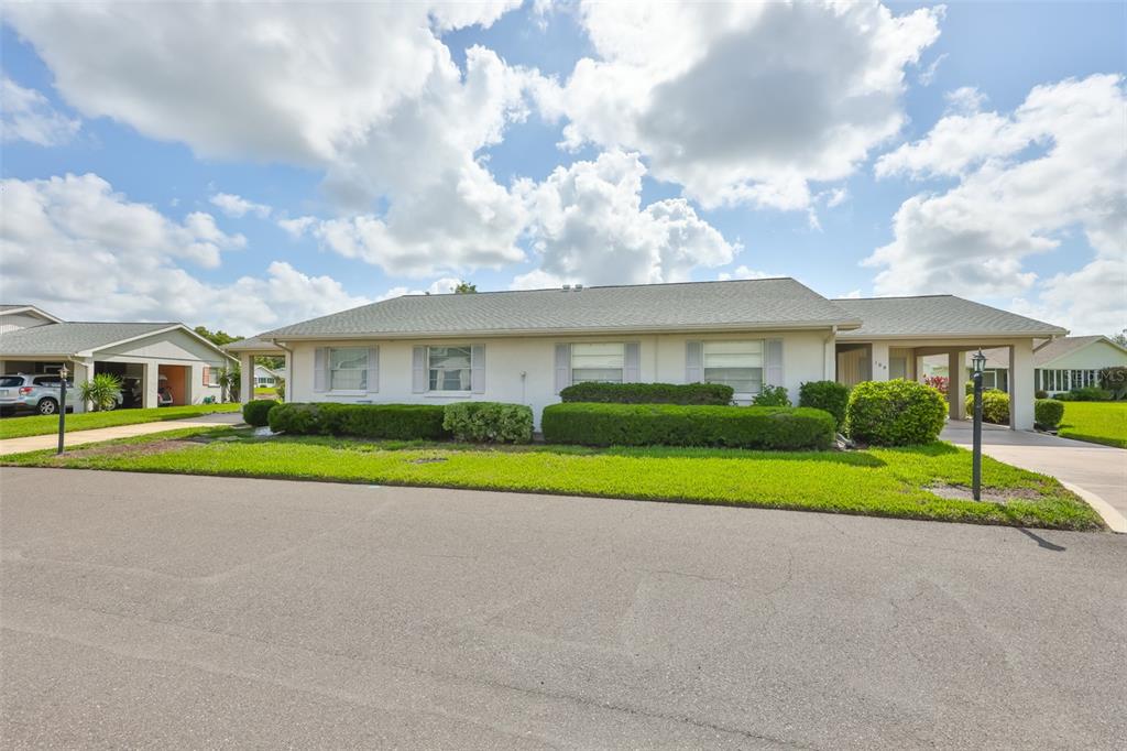 A single-story house with a light-colored exterior, a gray roof, and a manicured lawn — 109 GLENDOWER CIRCLE, SUN CITY CENTER, FL