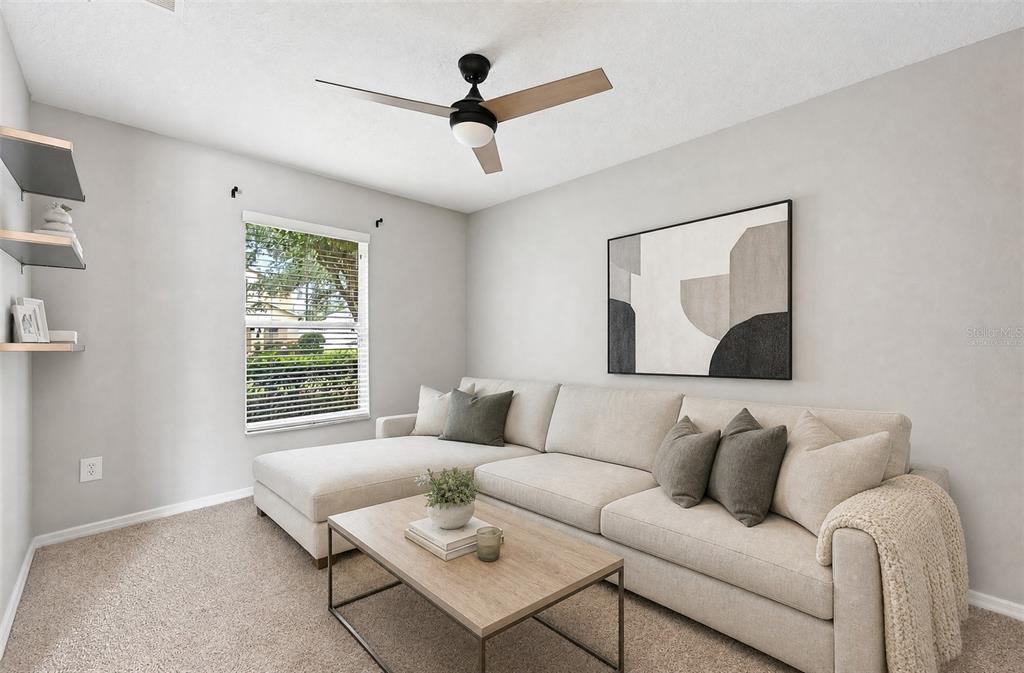 A carpeted bedroom with a ceiling fan, two wall shelves, and an adjacent tiled hallway — 2564 ABEY BLANCO DRIVE, ORLANDO, FL
