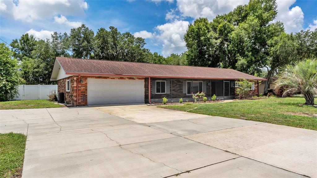 A brick exterior house features a covered porch and a bright red double front door — 3180 FLAMINGO LANE, MULBERRY, FL