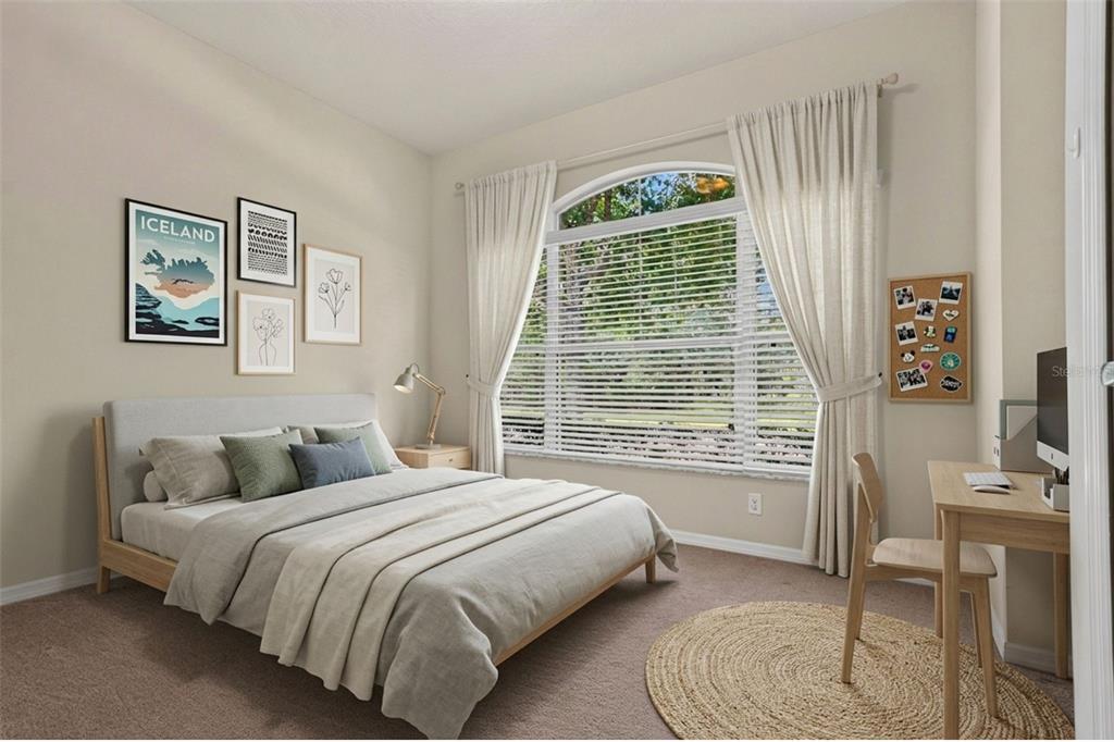 A bedroom features a bed, a desk, and a large arched window with white curtains — 11231 BELLE HAVEN DRIVE, NEW PORT RICHEY, FL