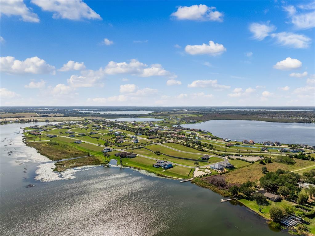 An aerial view shows a residential neighborhood situated on a peninsula surrounded by lakes — 535 ADAMS VIEW LANE, AUBURNDALE, FL