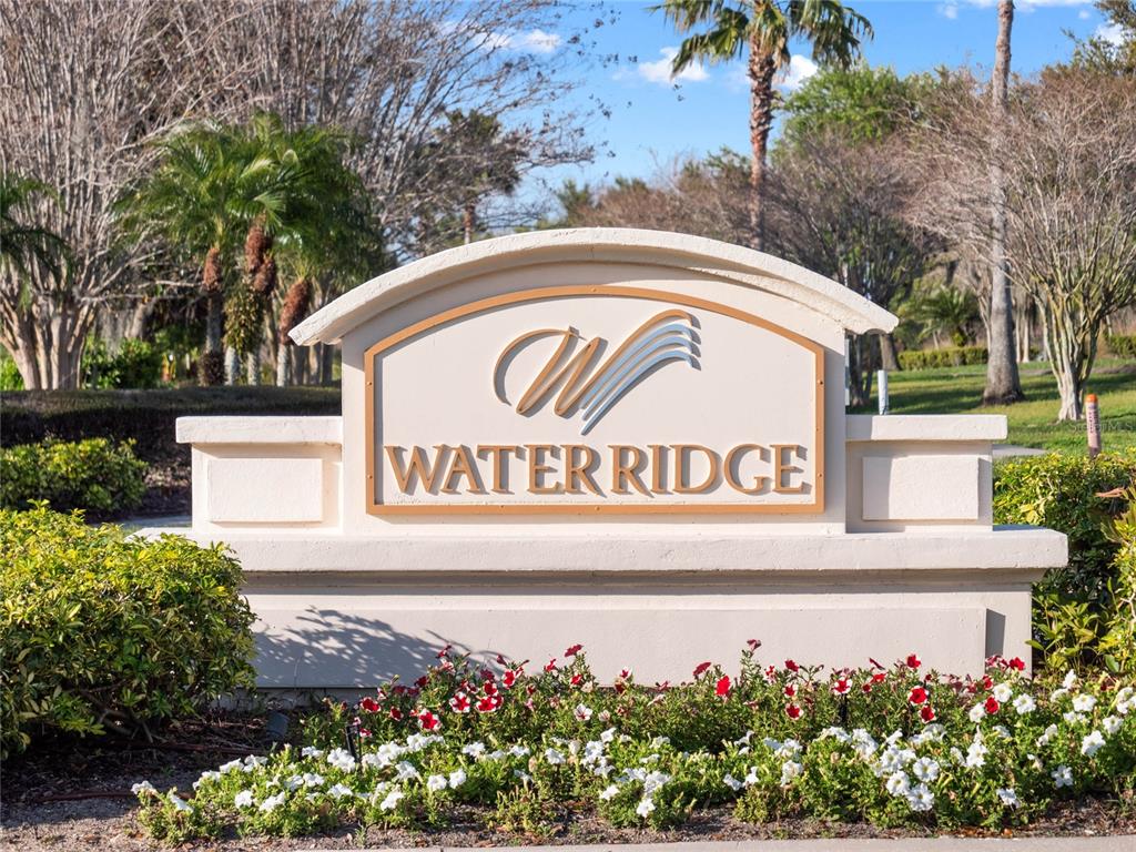 A beige monument sign for Water Ridge stands in front of trees and flowers — 535 ADAMS VIEW LANE, AUBURNDALE, FL