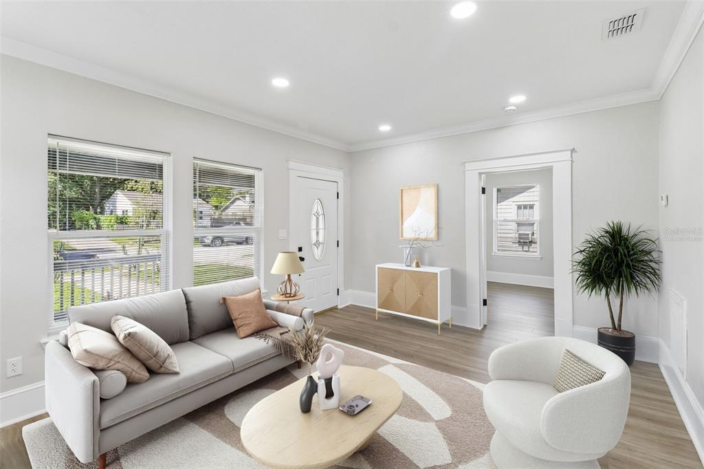 A modern kitchen features white cabinets, stainless steel appliances, and marble-patterned countertops and backsplash — 43 W MURIEL STREET, ORLANDO, FL