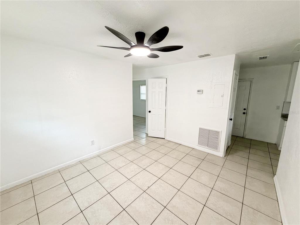 A room with white walls, a ceiling fan, and light-colored tile flooring — 3916 E GENESEE STREET, TAMPA, FL
