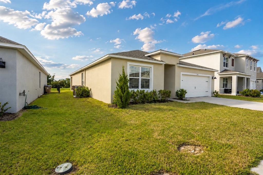 A single-story beige stucco house with a white garage door and a green lawn — 2791 HOUSE FINCH ROAD, ST CLOUD, FL