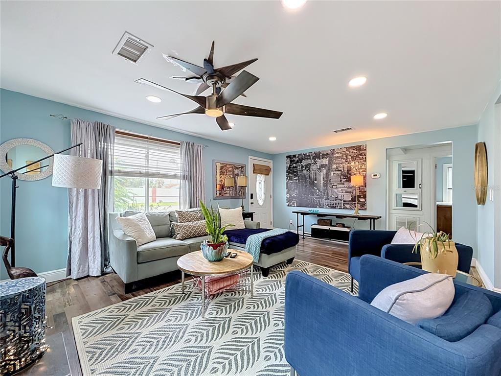 A living room with light blue walls, a fireplace, and an adjacent dining area — 4831 FAIRFIELD AVENUE S, ST PETERSBURG, FL