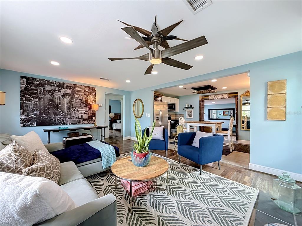 A kitchen features white cabinets, a stainless steel dishwasher, a light blue wall, and a mirror — 4831 FAIRFIELD AVENUE S, ST PETERSBURG, FL