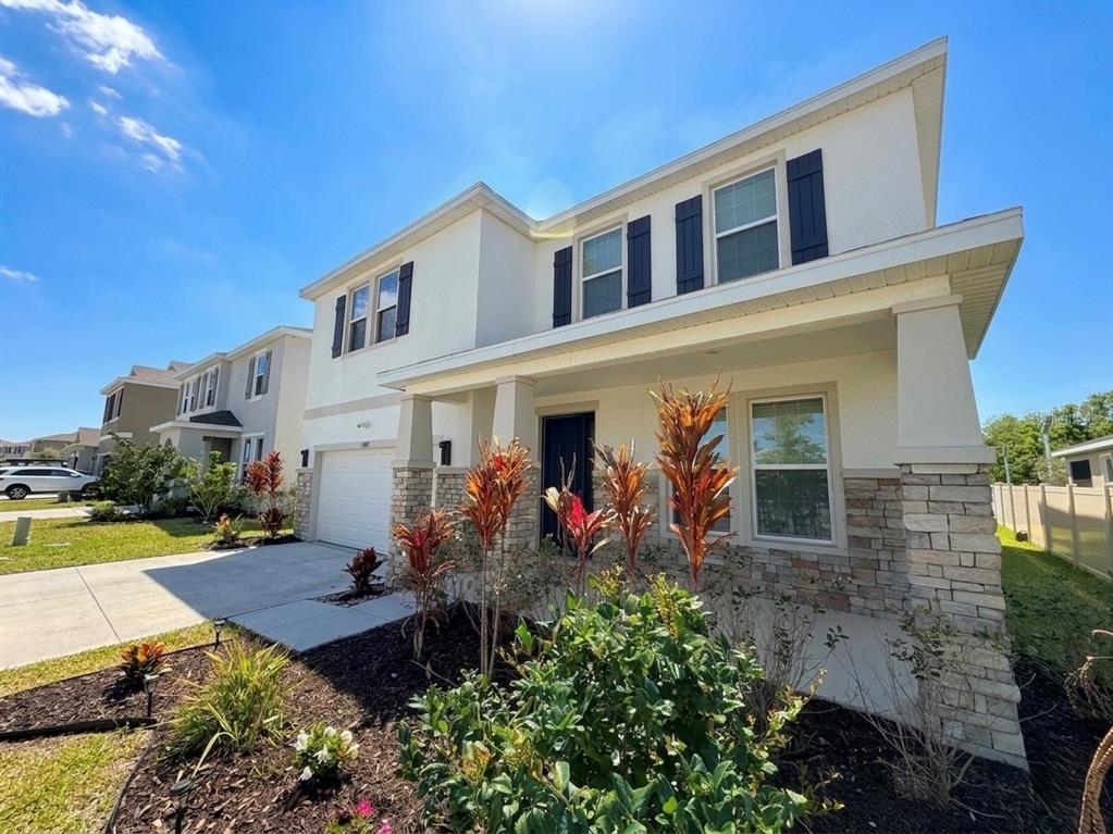 A two-story house with white stucco, stone veneer, and a covered front porch — 16910 OVAL RUM DRIVE, WIMAUMA, FL