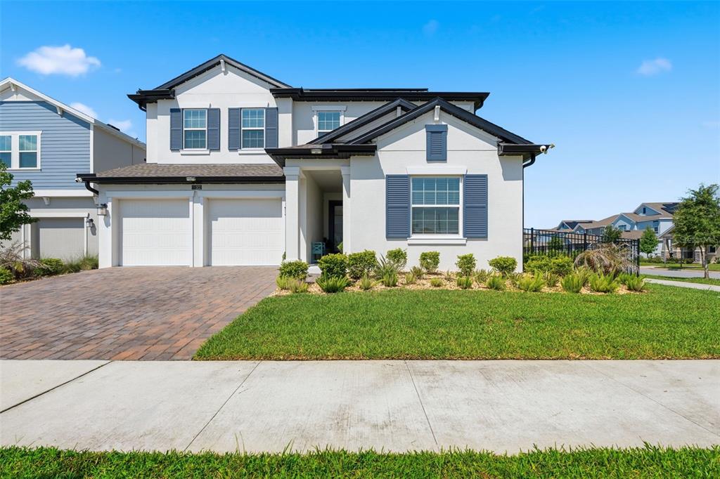 A two-story house with a white stucco exterior, blue shutters, and a two-car garage — 11502 PARAGRAPH ROAD, ORLANDO, FL
