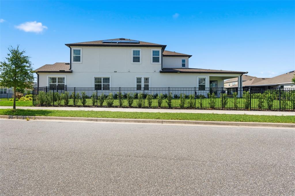 A two-story house with a black metal fence and solar panels on the roof — 11502 PARAGRAPH ROAD, ORLANDO, FL