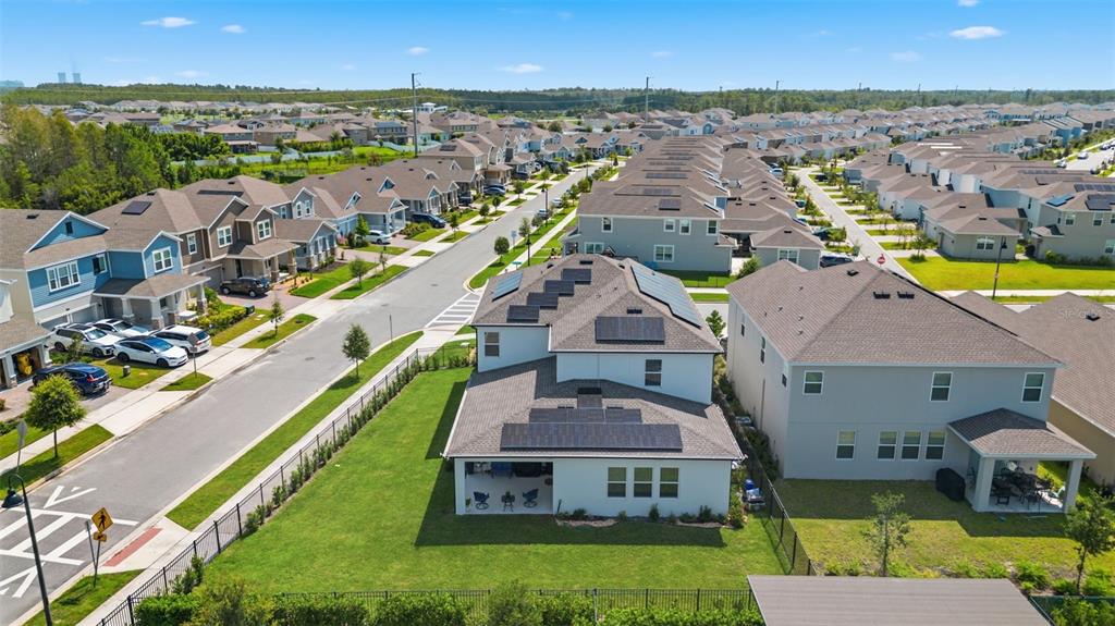 An aerial view shows a suburban neighborhood with houses featuring solar panels on their roofs — 11502 PARAGRAPH ROAD, ORLANDO, FL