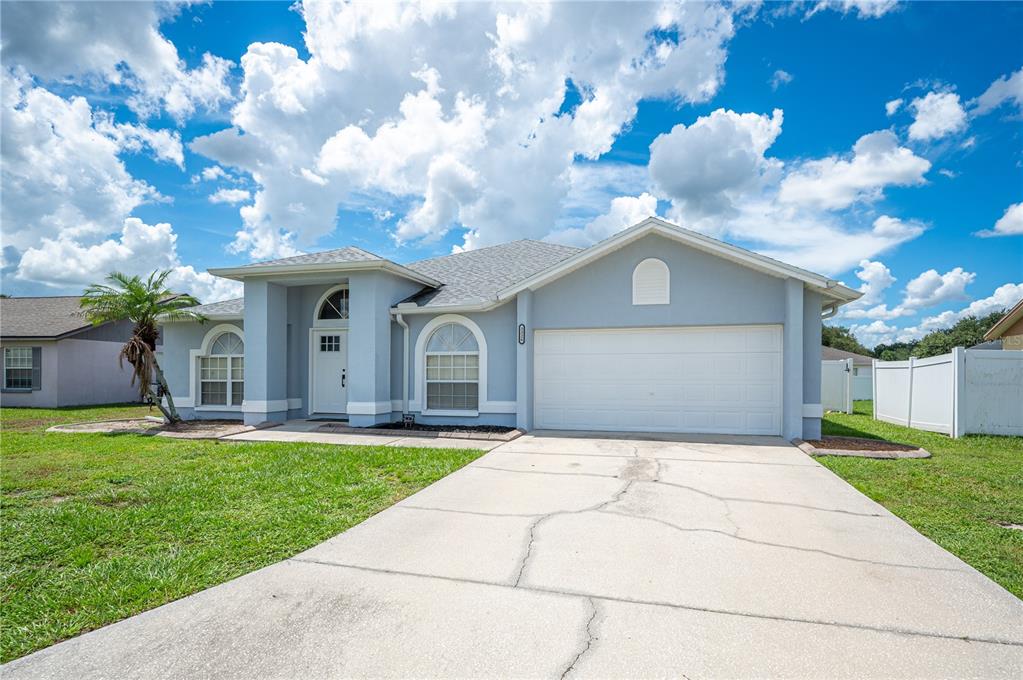 A light blue single-story house with a white garage door and a concrete driveway — 3326 MERLOT DRIVE, LAKELAND, FL