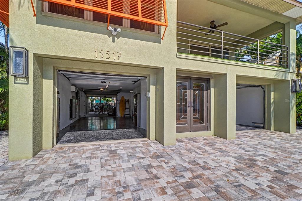 The exterior of a house features a paved driveway, a garage, and a covered balcony — 15517 GULF BOULEVARD, REDINGTON BEACH, FL