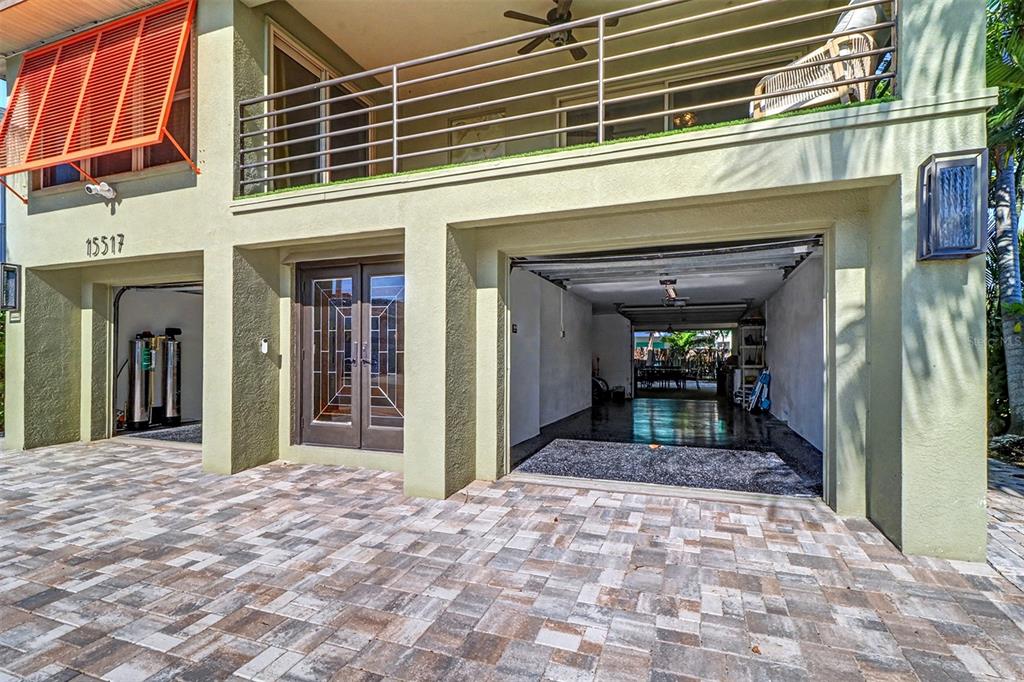 The exterior of a house features a paved driveway, a garage, and an upper balcony — 15517 GULF BOULEVARD, REDINGTON BEACH, FL