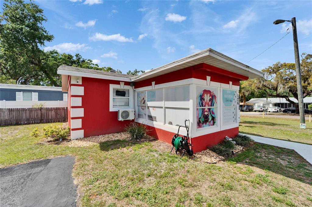 A red exterior building with white trim and a dog grooming sign on the window — 126 RIDGEWOOD AVENUE, BRANDON, FL