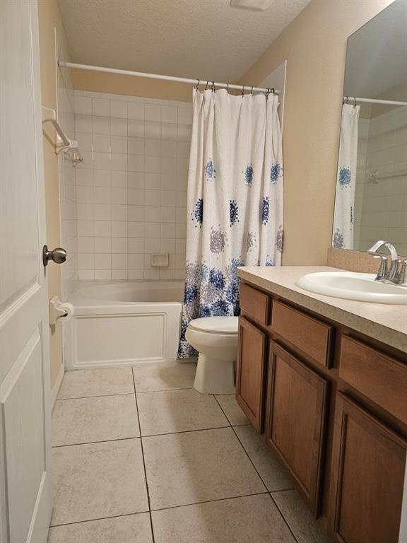 A bathroom features a white tub-shower combination, a toilet, and a wooden vanity with sink — 5408 QUARRY ROCK ROAD, LAKELAND, FL