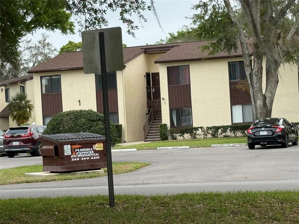 An exterior view shows a concrete staircase leading to two upper-level apartment doors — 737 MIDWAY DRIVE UNIT A, OCALA, FL