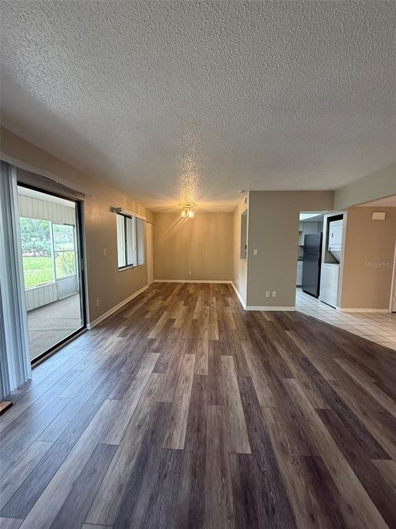 An open-concept living and dining area features wood-look flooring and a sliding glass door — 737 MIDWAY DRIVE UNIT A, OCALA, FL