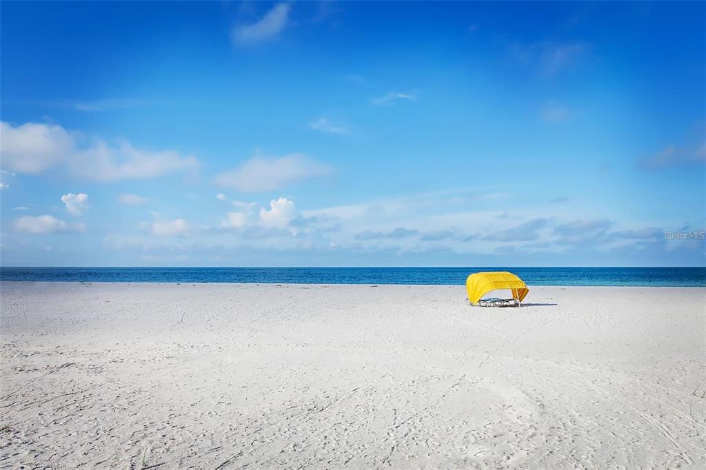 An aerial view shows a vacant waterfront lot with two wooden docks and palm trees — 1 PARADISE LANE, TREASURE ISLAND, FL