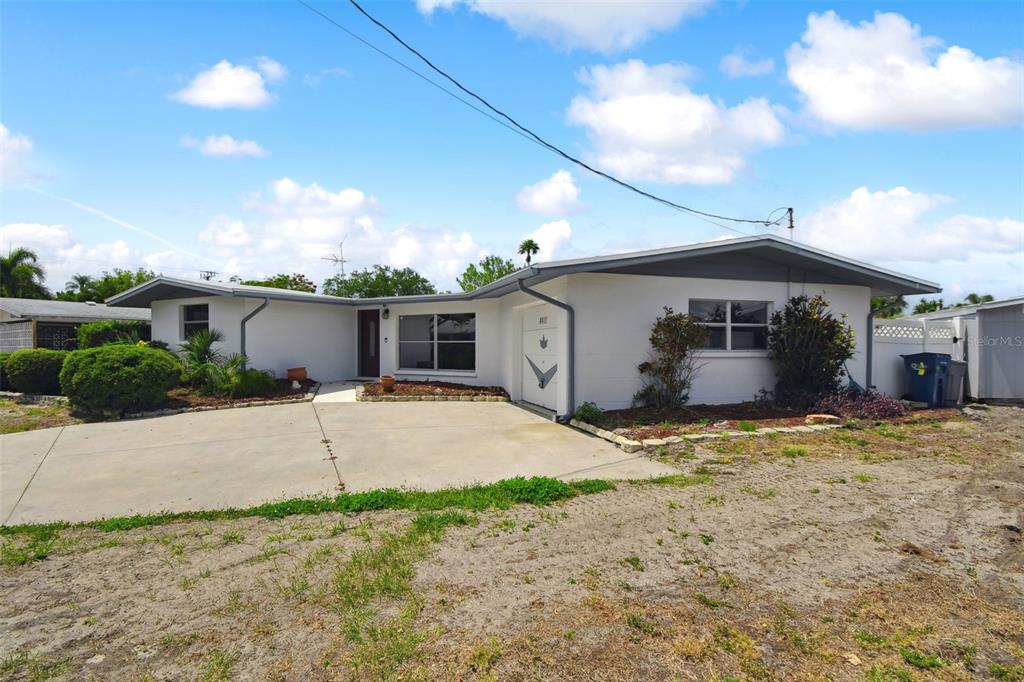 A single-story white house with a concrete driveway and a small attached garage — 4411 3RD AVENUE E, BRADENTON, FL