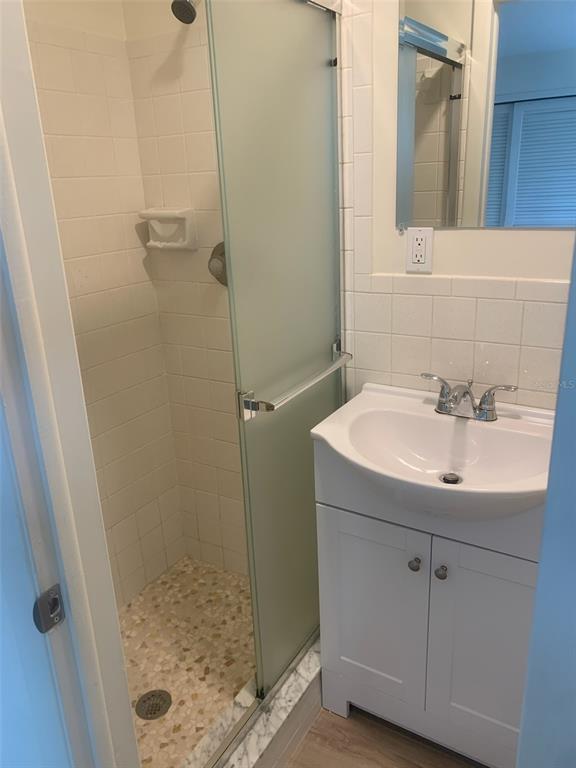 A white brick house exterior features a light blue front door and matching window shutters — 10186 45TH WAY N, PINELLAS PARK, FL