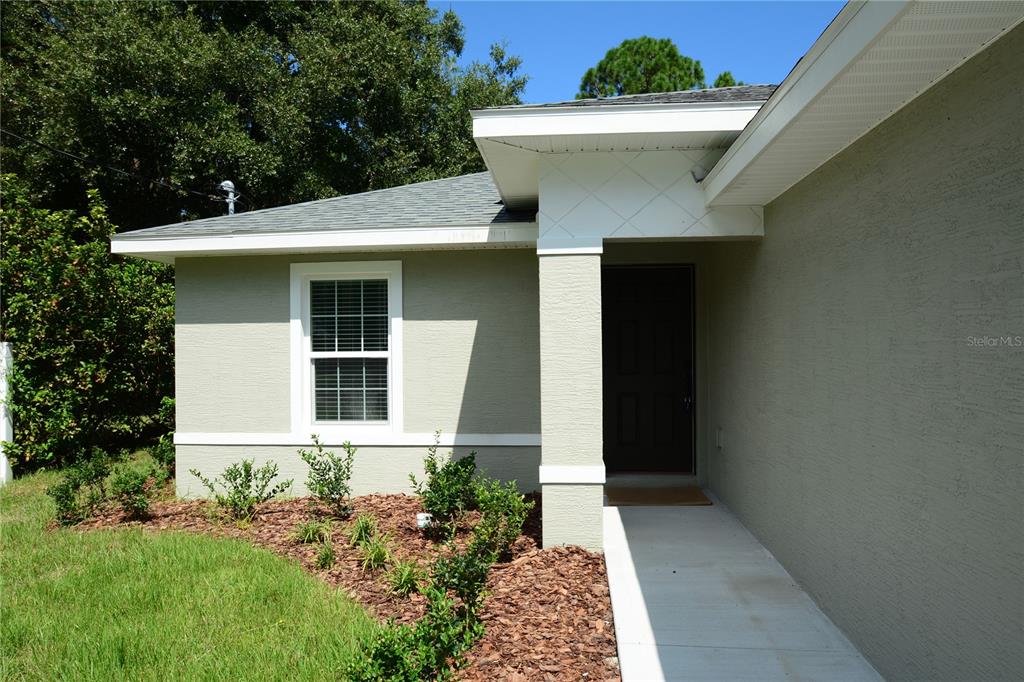 A light-colored house exterior features a front door, a window, and a concrete walkway — 148 SECRETARY TRAIL UNIT A/B, PALM COAST, FL