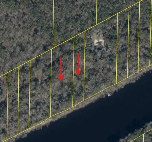An aerial view shows several wooded waterfront lots outlined in yellow with red arrows — 893 NE 930 STREET, OLD TOWN, FL