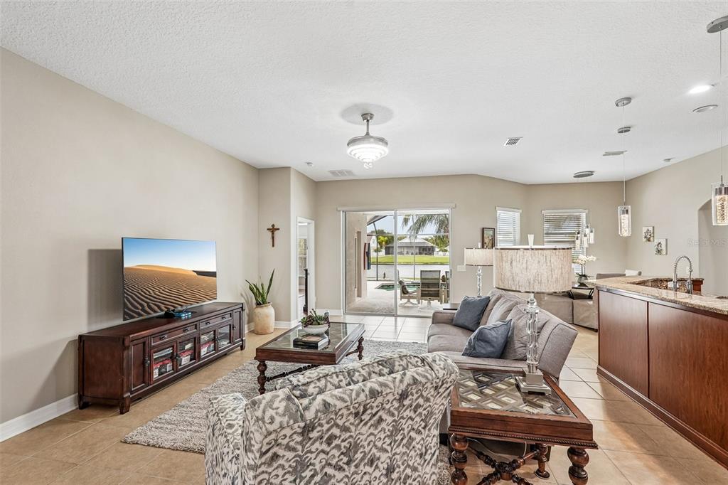 A living room with tile floors, a television console, and a view of a pool — 5319 120TH AVENUE E, PARRISH, FL