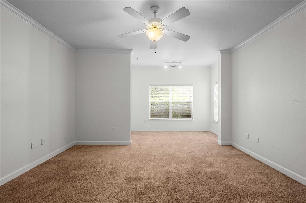 An empty room with beige carpet, white walls, a ceiling fan, and a window — 18525 BRIDLE CLUB DRIVE UNIT 18525, TAMPA, FL