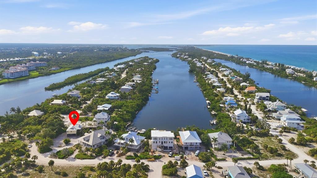 An aerial view shows a coastal neighborhood with houses situated along a central waterway — 97 KETTLE HARBOR DRIVE, PLACIDA, FL