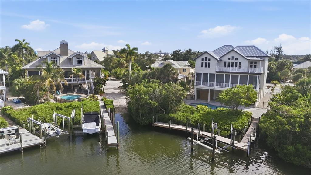 An aerial view shows two waterfront houses with private docks and swimming pools — 97 KETTLE HARBOR DRIVE, PLACIDA, FL