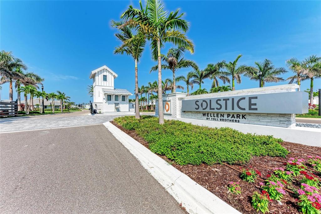 A stone monument sign for Solstice at Wellen Park stands beside a gated community entrance — 18530 MIDSUMMER PLACE, VENICE, FL