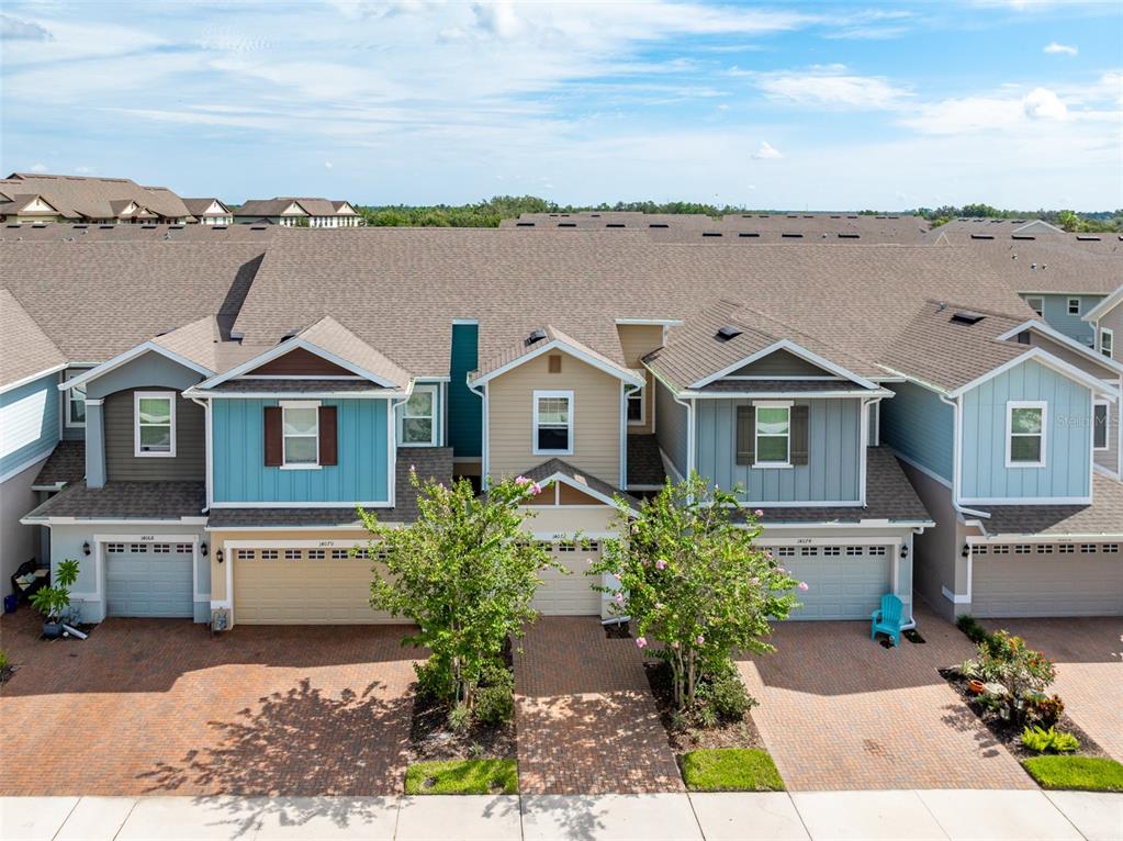 An aerial view of a row of attached townhomes with brick driveways and garages — 14072 KITE LANE, LITHIA, FL