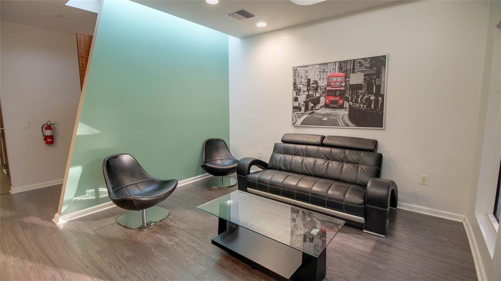 A modern waiting area features two black swivel chairs, a sofa, and a glass coffee table — 8865 COMMODITY CIRCLE UNIT 105, ORLANDO, FL