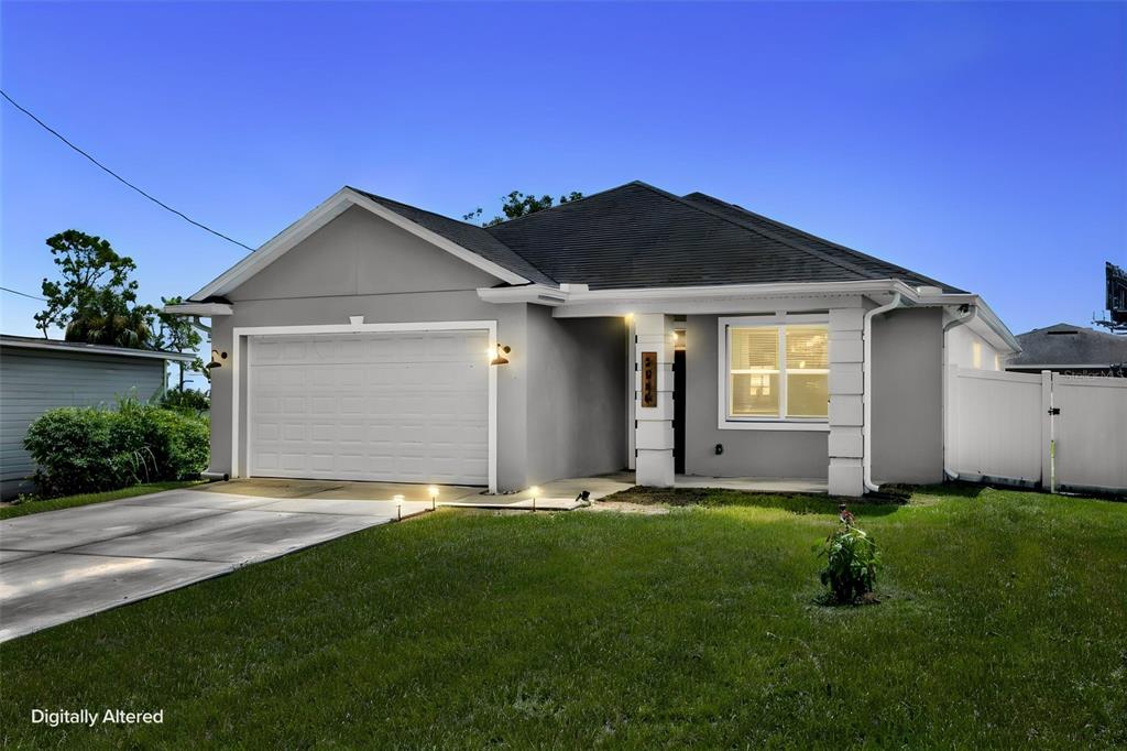 A single-story gray house with a two-car garage and a white vinyl fence — 5060 GYPSY LANE, ORLANDO, FL