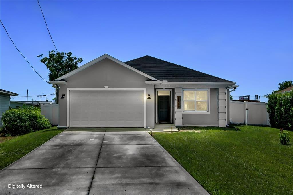 A single-story house with a gray exterior, a two-car garage, and a concrete driveway — 5060 GYPSY LANE, ORLANDO, FL
