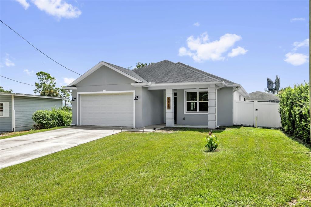A single-story gray house with a two-car garage and a front lawn — 5060 GYPSY LANE, ORLANDO, FL
