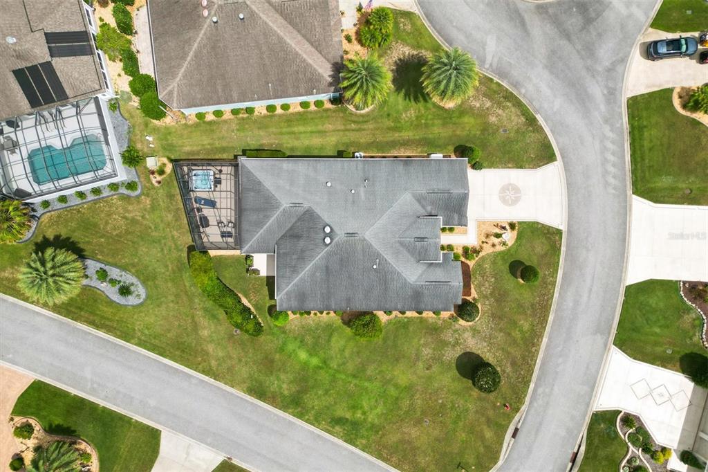 An aerial view shows a house with a screened pool enclosure and a circular driveway — 1451 LUCKETT COURT, THE VILLAGES, FL