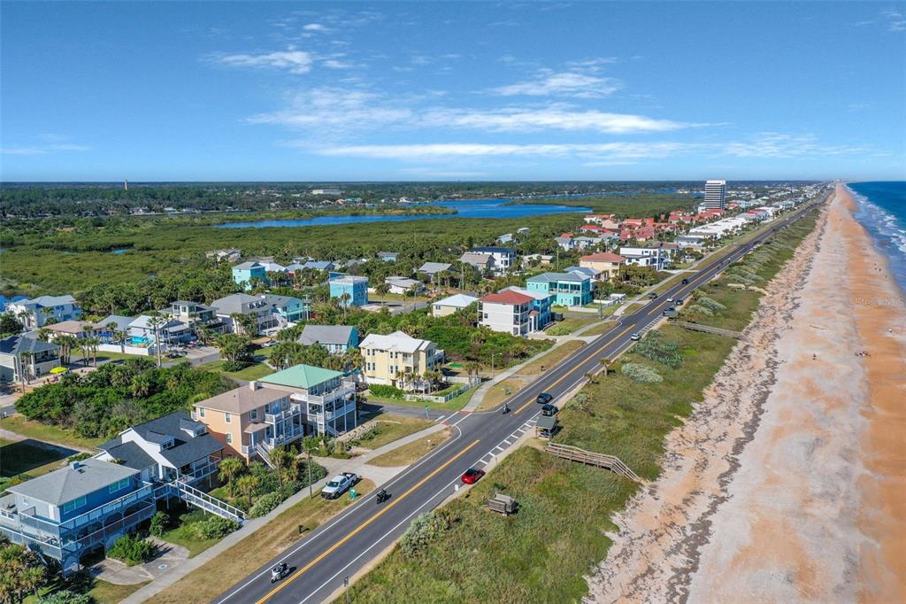 An aerial view shows a coastal road running parallel to a beach with residential houses — N OCEAN BOULEVARD, FLAGLER BEACH, FL