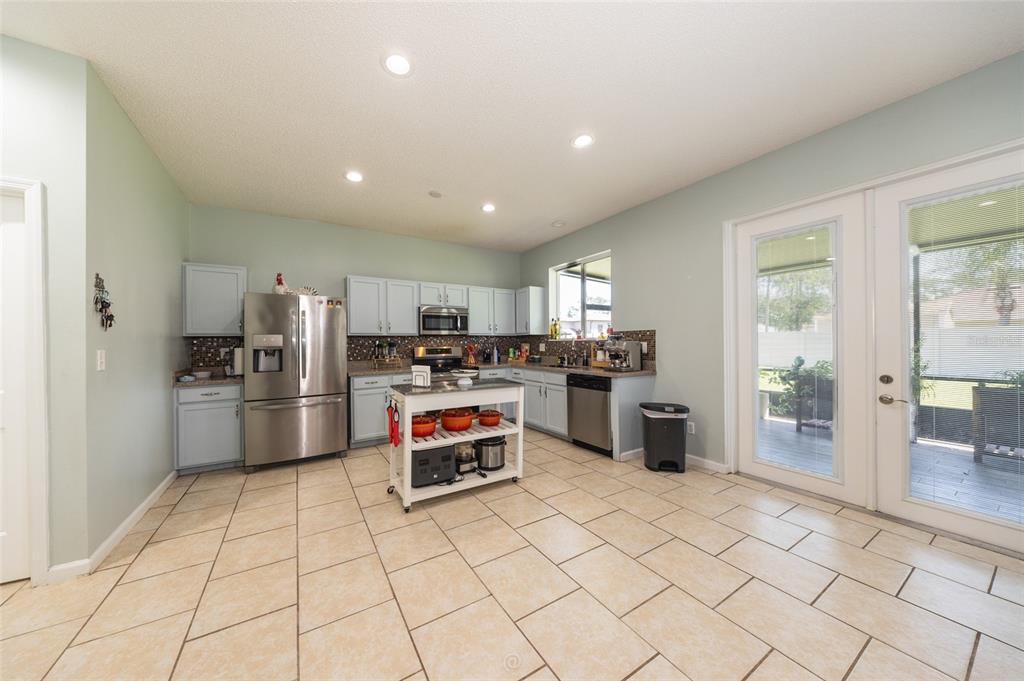 A kitchen with light blue cabinets, stainless steel appliances, a center island, and tile flooring — 6 RYBARK LANE, PALM COAST, FL