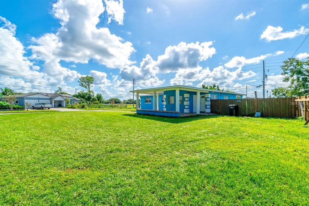 A blue house with a covered patio sits on a large, grassy lot — 804 ENGEL DRIVE, ORLANDO, FL