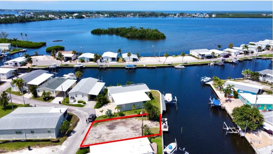 An aerial view shows a vacant waterfront lot outlined in red next to a canal — 280 NASSAU DRIVE, PALMETTO, FL