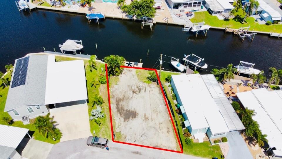 An aerial view shows a vacant waterfront lot situated between two existing residential properties — 280 NASSAU DRIVE, PALMETTO, FL
