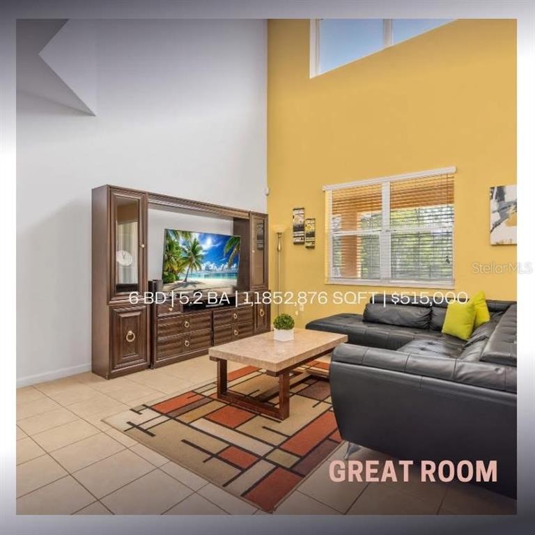 A great room features high ceilings, tile floors, a large entertainment center, and leather seating — 411 CABELLO DRIVE, DAVENPORT, FL