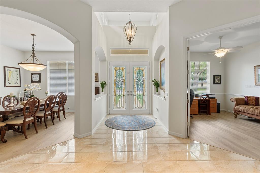 A bright entryway features tile flooring, a circular rug, and double doors with stained glass — 5603 EAGLEGLEN PLACE, LITHIA, FL