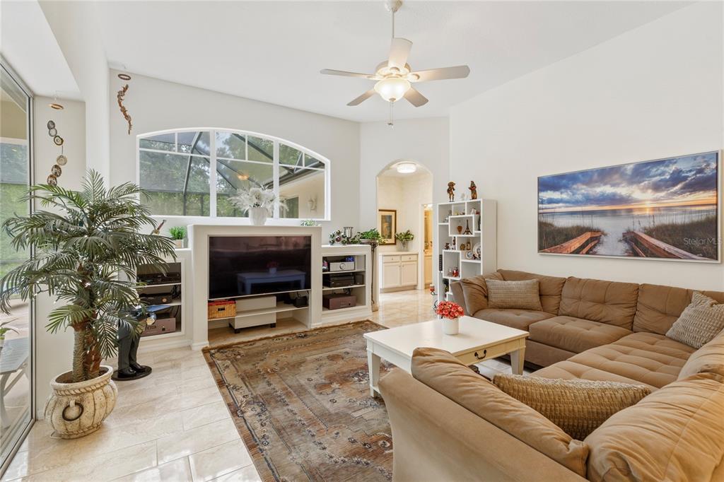 A living room features a large sectional sofa, a television console, and a ceiling fan — 5603 EAGLEGLEN PLACE, LITHIA, FL